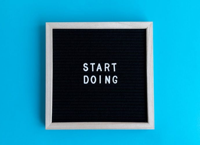 Black letter board with 'START DOING' text on a vibrant blue background.