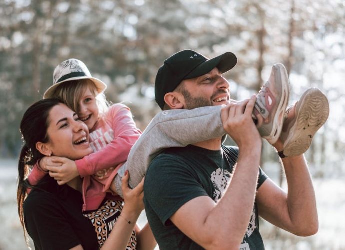 Happy family having fun in a forest, capturing joyful bonding moments.