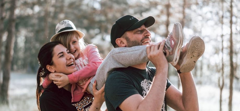 Happy family having fun in a forest, capturing joyful bonding moments.